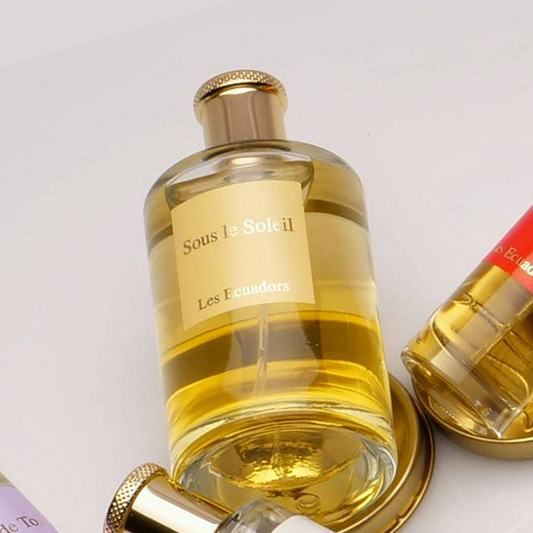 liggende afumfles op een metalen ronde schijf met een geel vierkant label met de tekst sous les soleil en daaronder het merk Les Ecuadors