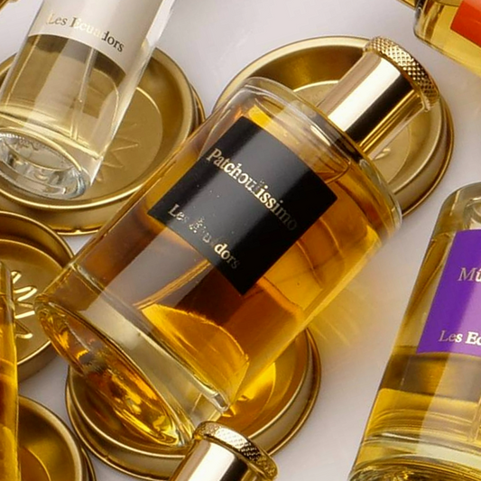 diverse flessen liggend op goud metalen ronde schijfjes met in het midden een flews met een zwart virkant loge en gouden letters