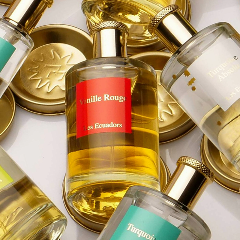 parfumflessen door elkaar met metalen deksels met een logo centrale fles is vanille rouge van les ecuadors