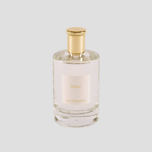 parfumfles tegen een witte achtergrond met een gouden dop en de tekst Musc op een ecru label