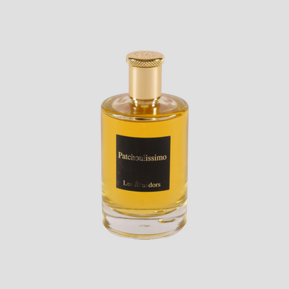 perfumfles met een witte achtergreond en een vierkant zwart label en gouden tekst Patchoulissimo Les Ecuadors