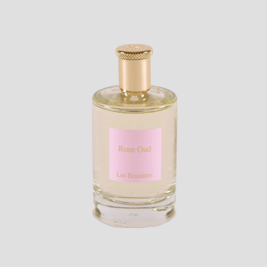 parfumfles witte achtergrond en gouden dop de fles heeft een roze label met de tekst Rose oud Les ecuadors