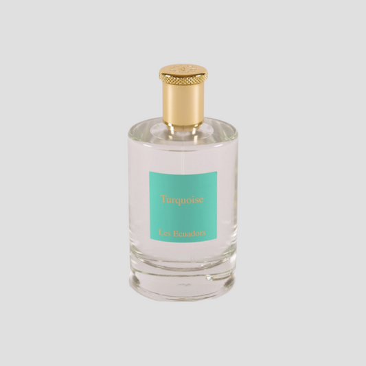 parfumfles tegen een witte achtergrond met gouden dop en een blauw/groen label met de gouden letters Turquoise Les Ecuadors